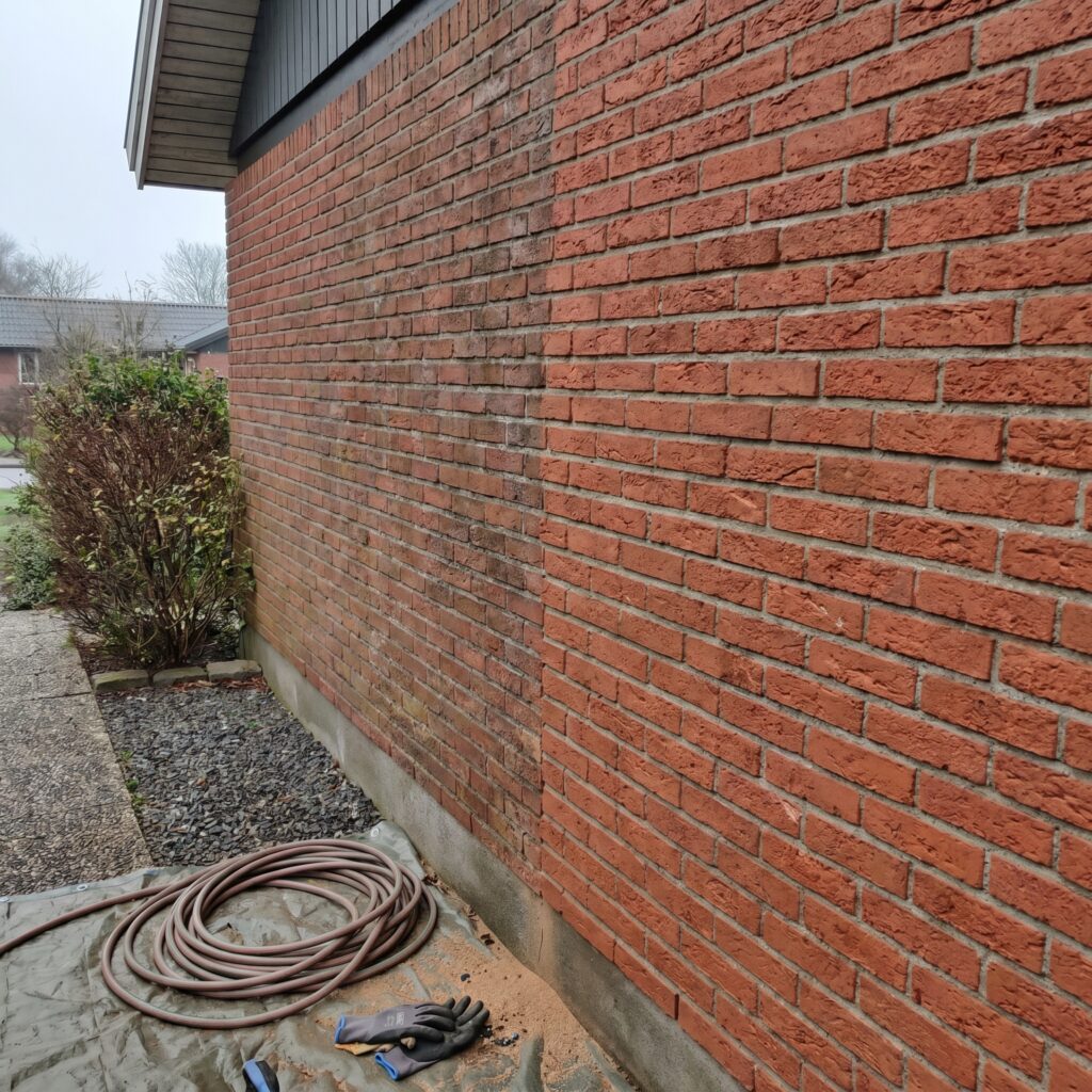 overlap-facade, facade_masonry, detail, outdoor, facade,murværk,omfugning,pudsning,sandblæsning,sokkel,mursten,renovering, Detalje af sandblæst murstensoverflade med tydelig forskel mellem renset og urenset område., på et rødt murstensparcelhus fra 1970erne., dansk bolig, håndværk, renovering, vedligeholdelse, pris, tilbud, facade_masonry, detail, outdoor, facade,murværk,omfugning,pudsning,sandblæsning,sokkel,mursten,renovering