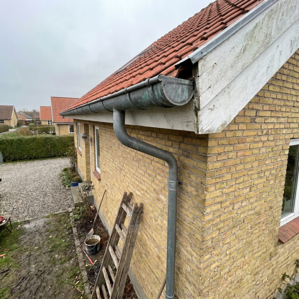 overlap-tag, roof_chimney, detail, outdoor, tag,skorsten,tagrender,inddækning,tagsten,rygning,vedligehold,reparation, Detalje af tagrende, nedløb og sternbræt på dansk parcelhus., i overskyet skandinavisk dagslys., dansk bolig, håndværk, renovering, vedligeholdelse, pris, tilbud, roof_chimney, detail, outdoor, tag,skorsten,tagrender,inddækning,tagsten,rygning,vedligehold,reparation