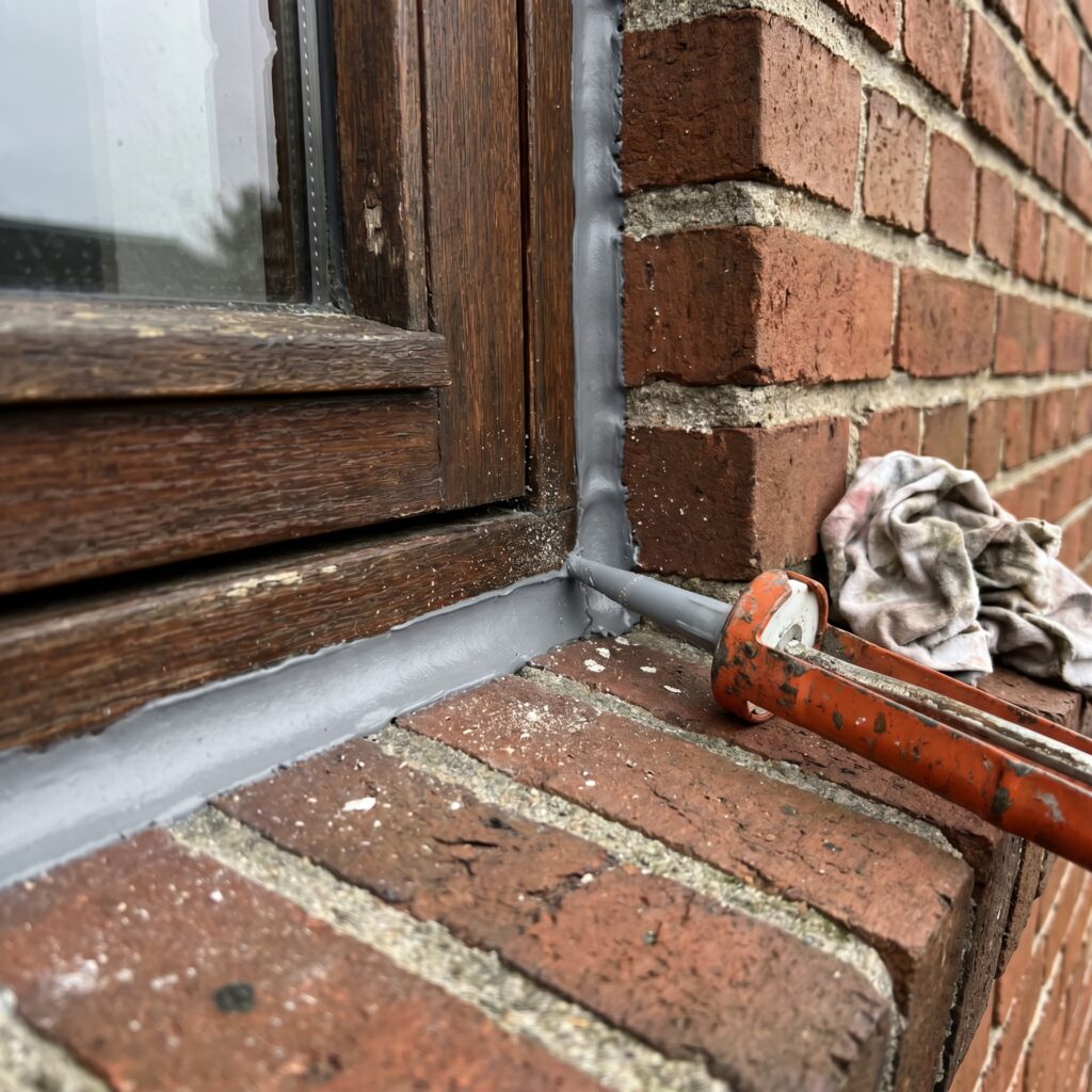overlap-vinduer-doere, windows_doors, detail, mixed, vinduer,døre,glas,karme,fuger,fugebånd,tætning,udskiftning,vedligehold, Nærbillede af vinduesfuge, karm og murværk med ny tætning., på en rød murstensvilla., dansk bolig, håndværk, renovering, vedligeholdelse, pris, tilbud, windows_doors, detail, mixed, vinduer,døre,glas,karme,fuger,fugebånd,tætning,udskiftning,vedligehold