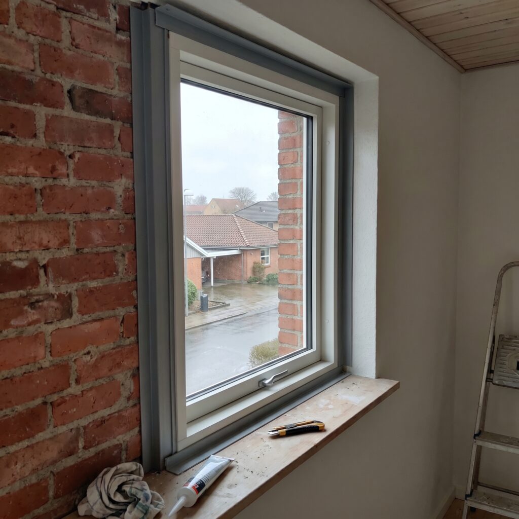 overlap-vinduer-doere, windows_doors, detail, mixed, vinduer,døre,glas,karme,fuger,fugebånd,tætning,udskiftning,vedligehold, Detalje af fugebånd omkring nyt vindue i dansk murstensfacade., i en lys dansk stue., dansk bolig, håndværk, renovering, vedligeholdelse, pris, tilbud, windows_doors, detail, mixed, vinduer,døre,glas,karme,fuger,fugebånd,tætning,udskiftning,vedligehold